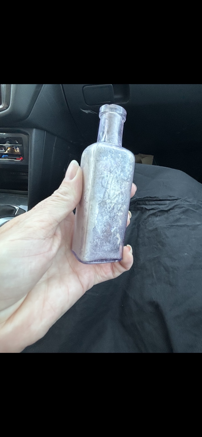 Manda holding the purple glass bottle she found in the Utah desert.